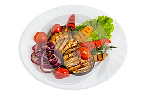 Vegetable salad on white plate with grilled eggplant, cherry tomatoes, red and yellow bell peppers, purple onions, dill, lettuce