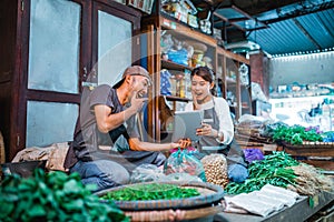 vegetable sellers looked surprised while holding tablet