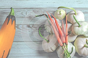 Vegetable set: carrots, patisons with green tails and multi-colored zucchini lie on an old wooden table