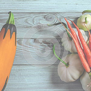 Vegetable set: carrots, patisons with green tails and multi-colored zucchini lie on an old wooden table