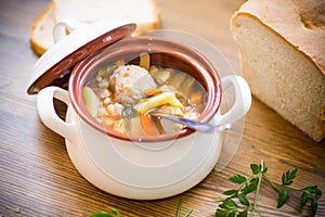 Vegetable soup with beans and meatballs in a ceramic bowl