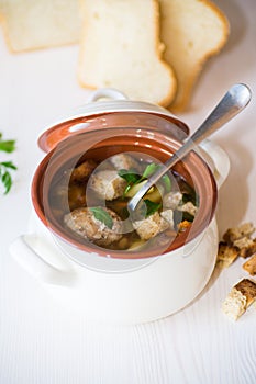 Vegetable soup with beans and meatballs in a ceramic bowl