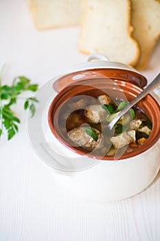 Vegetable soup with beans and meatballs in a ceramic bowl