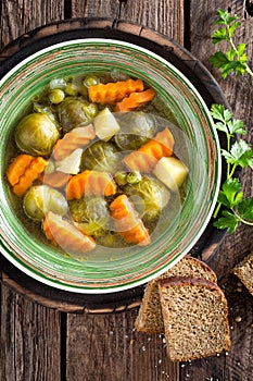 Vegetable soup with brussel sprouts on wooden rustic table