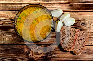 Vegetable soup in a glass bowl on wooden table. Top view