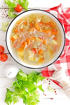 Vegetable soup. Healthy food, vegetarian dish. Vegetable soup with cabbage, potato, tomato, carrot, celery, pepper and green peas.