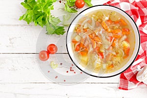 Vegetable soup. Healthy food, vegetarian dish. Vegetable soup with cabbage, potato, tomato, carrot, celery, pepper and green peas.