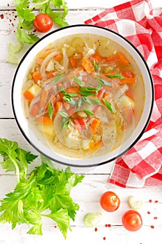 Vegetable soup. Healthy food, vegetarian dish. Vegetable soup with cabbage, potato, tomato, carrot, celery, pepper and green peas.