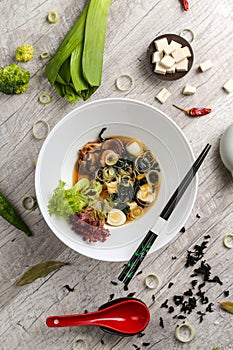 Vegetable soup with meat, noodles and vegetables in a white plate