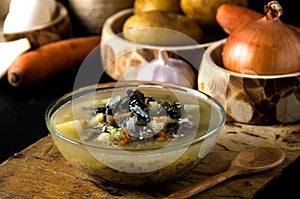 Vegetable soup mushrooms glass bowl wooden spoon