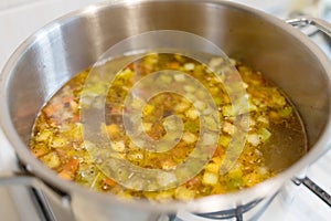 Vegetable soup in the pan in the kitchen on the stove. Dinner time. Ready to eat