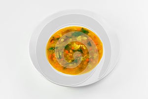 Vegetable soup in a plate on a white background. The view from the top