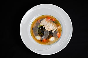 Vegetable soup with quail eggs and herbs