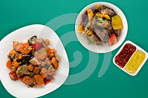 Vegetable stew on a white plate. stewed vegetables on a colored background. vegetarian food