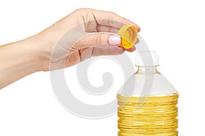 vegetable or sunflower oil in plastic bottle with hand isolated on white background