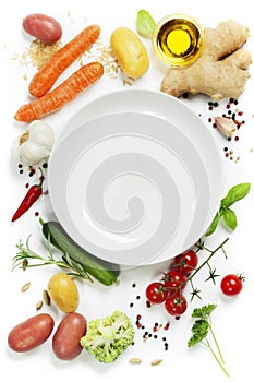 Vegetables around empty white plate