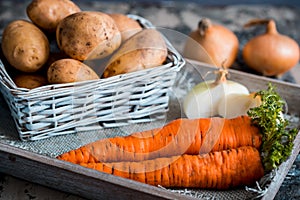 Vegetables in a basket: beets, onions, garlic, dill, potatoes, carrots on an old wooden background