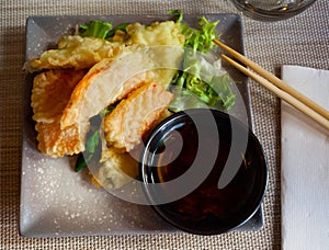 Vegetables in batter with with soy sauce on ceramic plate.