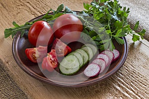 Vegetables in a ceramic plate on an uncouth board. Low-calorie diet concept
