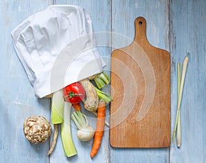 Vegetables in chef's hat and empty cutting board