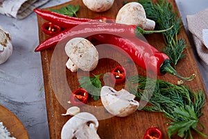 Vegetables on cutting board, plate with salt over white textured background, close-up, selective focus.