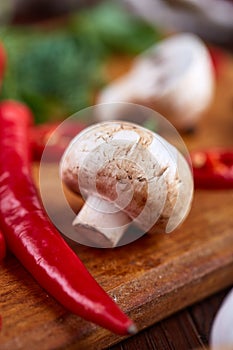 Vegetables on cutting board, plate with salt over white textured background, close-up, selective focus.