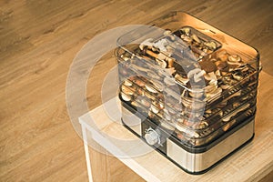 Vegetables dryer on wooden table with wooden background. Preparing for drying mushrooms