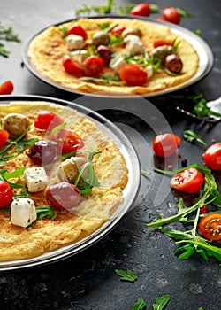 Vegetables Eggs Omelette with tomatoes, wild rocket, greek cheese, olives in a plate. Morning breakfast. healthy food