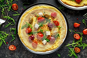 Vegetables Eggs Omelette with tomatoes, wild rocket, greek cheese, olives in a plate. Morning breakfast. healthy food