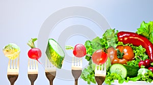 Vegetables on forks on a background of fresh vegetables