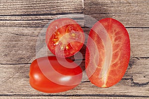 Vegetables of fresh tomatoes, whole and sectioned, on wooden plank