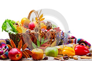 Vegetables and fruit in a wicker basket, isolated on white.