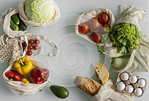 Vegetables, fruits, eggs in reusable eco cotton bags on table. Zero waste shopping concept. Plastic free items. Multi