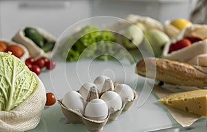 Vegetables, fruits, eggs in reusable eco cotton bags on table. Zero waste shopping concept. Plastic free items. Multi