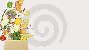 Vegetables and fruits in a paper bag on a white table. Online shopping. Banner. Culinary background for recipes. Food background.