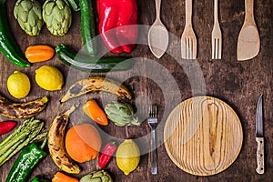 Vegetables and fruits on a rustic table with wooden plates and c