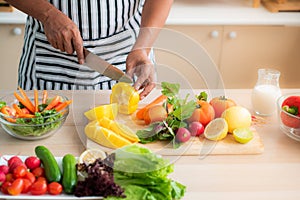 Vegetables and fruits such as mangos, lemons, bell peppers, tomatoes, carrots are prepared on the table