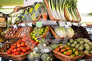 vegetables and fruits in wicker baskets on counter of greengrocery