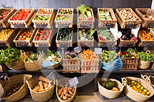 Vegetables and fruits in wicker baskets in greengrocery