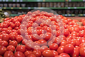 Vegetables are full of vitamins. Fresh and ripe tomatoes in a basket on a supermarket shelf. Ripe tomatoes in a supermarket