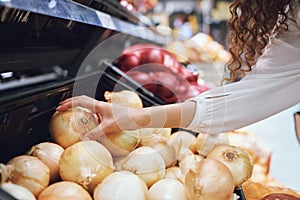 Vegetables, grocery shopping and health while a customer choose fresh onions in supermarket or greengrocer store. Close