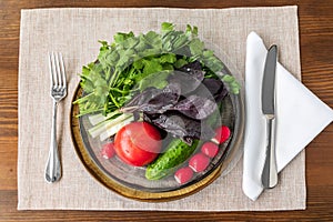 vegetables and herbs in a plate on a wooden table