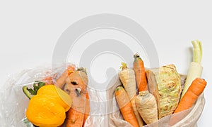 Vegetables from local market in reusable shopping bag and rotten spoiled vegetables in plastic shopping bag over light background