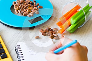 Vegetables and nuts on the scales. Calorie counting