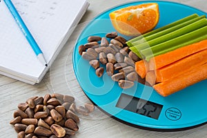 Vegetables and nuts on the scales. Calorie counting