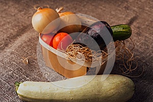 Vegetables, onions, eggplant, tomatoes and cucumbers in a basket. The concept of agriculture, healthy lifestyle, healthy eating