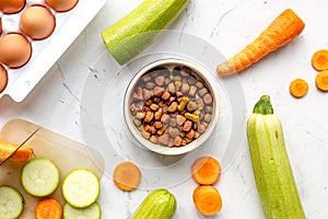 Vegetables and petfood on kitchen table background top view