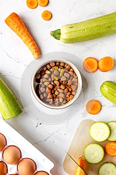 Vegetables and petfood on kitchen table background top view