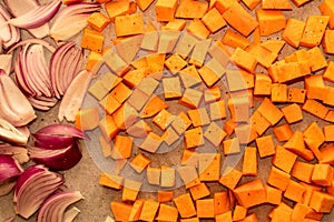 Vegetables - pumpkin and red onion - on a tray prepared for roasting in the oven