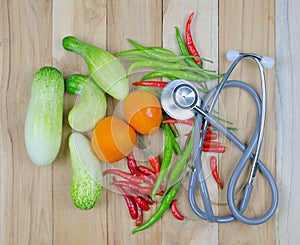 Vegetables and stethoscope on wooden table